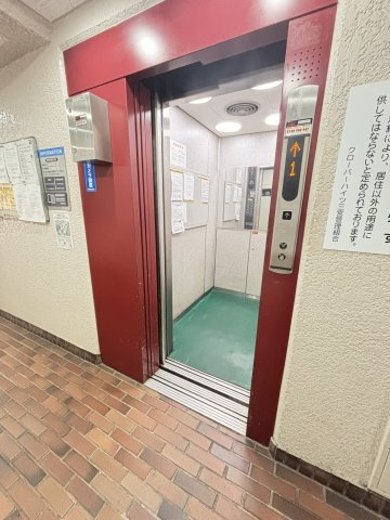 クローバーハイツ三宮のその他共用部分|【エレベーター】赤を基調としたフレームが特徴的なエレベーターです。内部には防犯カメラや案内掲示板が設置されています。