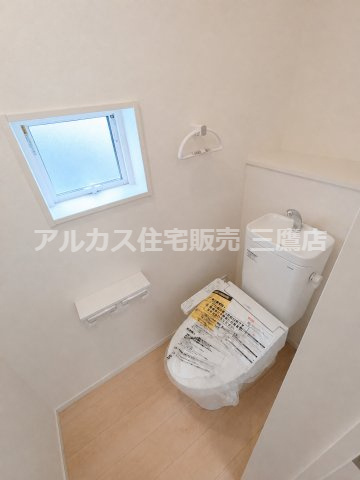 調布市富士見町3丁目 京王線 西調布駅 新築戸建のトイレ|温水洗浄便座と手洗いカウンターを備え、窓から明るい光が差し込む清潔感あるトイレです。