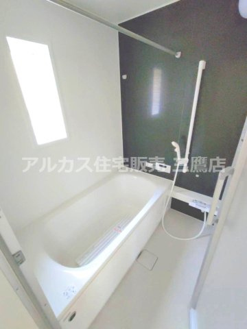 調布市富士見町3丁目 京王線 西調布駅 新築戸建の浴室|濃色の壁面がアクセントの浴室。窓と手すりを備え、すっきりとした設計です。