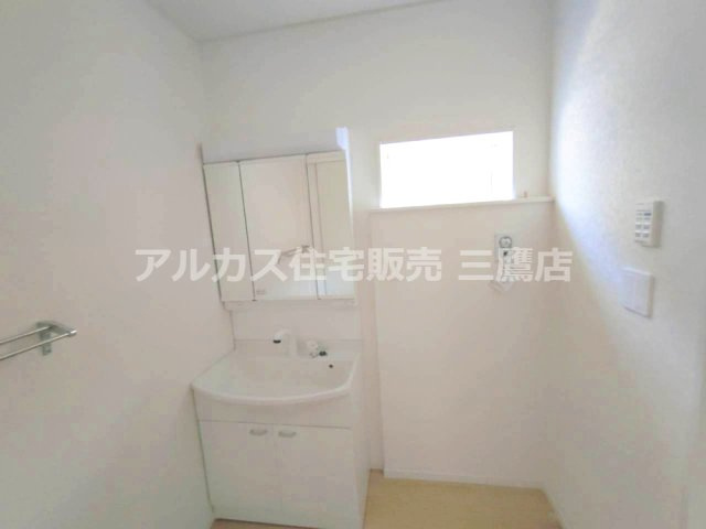 調布市富士見町3丁目 京王線 西調布駅 新築戸建の独立洗面台|洗面化粧台と小窓を備えた洗面室。洗濯機用水栓も確認できます。