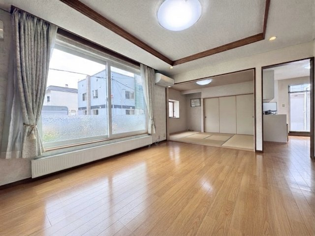 北49条東10丁目　一戸建ての居間・リビング|南向きの大きな開口窓から明るい日差しが差し込むリビングダイニング。隣接した和室を開け放つことでより広々とした空間使いができます♪※バーチャル加工により一部家具等を削除しております。