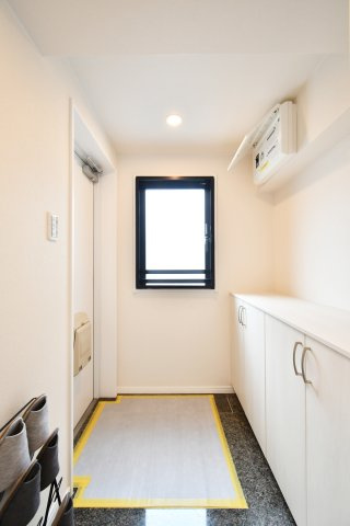 ローヤルシティ大宮吉敷町の玄関|大理石調の床材が住まいの品格を物語る玄関。小窓からの自然光が明るく、圧迫感のない収納棚は飾り棚としても重宝します。リフォーム済みの清潔感あふれる空間が、大切なゲストを優雅にお迎えします。