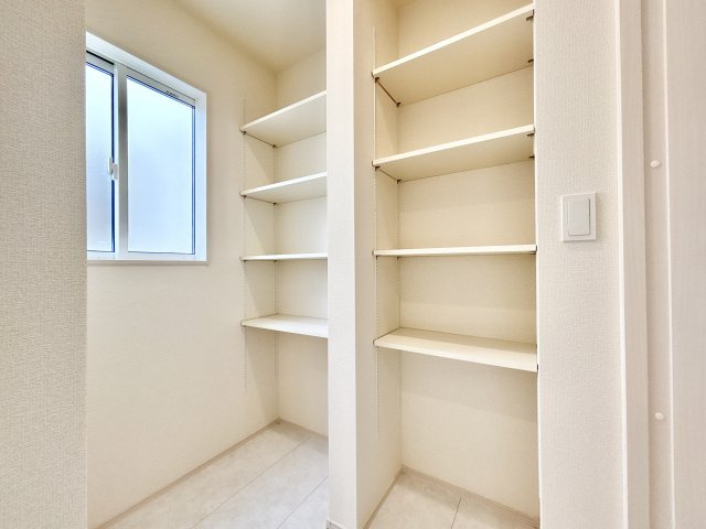 伊丹市鈴原町８丁目の収納|キッチンの横には用途に合わせて高さを調整できる4段の稼働棚を2列備えたパントリーがあり、食品のストックや食器等もすっきり片付けることができます。