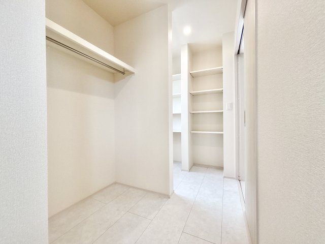 伊丹市鈴原町８丁目の収納|勝手口を備えた洗面室の隣には、ハンガーパイプ付きの収納も設置されており、家事動線に配慮された回遊性のある設計。「洗う・干す・畳む」工程が短い動線で完結できるため、家事を効率化できます。