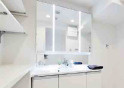 大宮大成町住宅の独立洗面台|三面鏡付き洗面台は朝の寝癖直しも楽々。鏡裏には歯ブラシセットやスキンケアも収納できて魅力的です！下の収納にもドライヤーや入浴グッツ、洗剤のストックなど…様々なものが収納できる便利な設備です！