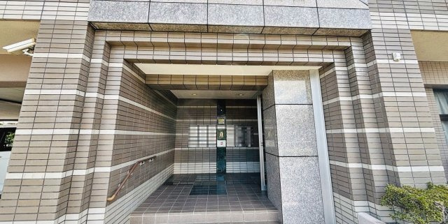 【エントランス】 | コモドヒル春日 | エントランスはシンプルながら洗練されたデザインでお住まいの方をお迎えします
