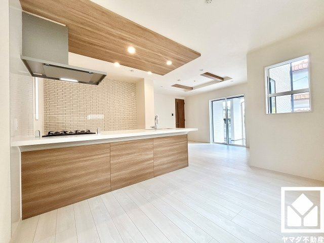 伊丹市鈴原町８丁目の居間・リビング|広々16.12帖のLDKが魅力。家族全員がリラックスできる、ゆったりとした快適リビングで温かい団らんの時間を。キッチンとは天井デザインで空間を仕切り、メリハリを演出します。