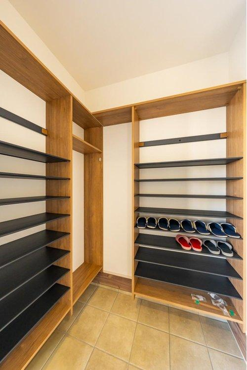 限定１邸！【秀光ビルド】豊田市野見山町分譲住宅の収納|シューズクローク：ウォークスルータイプの玄関収納は収納棚つきで収納量たっぷりで玄関をすっきり使えます。（2026年1月）撮影