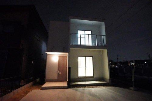【秀光ビルド】港区東茶屋分譲鉄筋コンクリート住宅C棟の外観|夜景外観正面：ホワイトが映え重厚感のある外壁とシルバーの玄関庇とバルコニー手摺でスタイリッシュな南側外観♪（2025年8月）撮影
