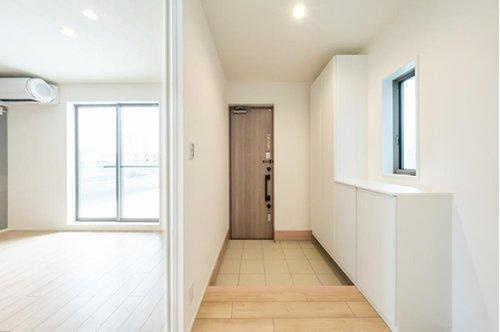 【秀光ビルド】港区東茶屋分譲鉄筋コンクリート住宅C棟の居間・リビング|リビング入口ハイドアとリビング階段：◎LDK入口のドアは透明なハイドアを採用。暗くなりがちな玄関ホールも明るくなっています♪（2026年2月）撮影