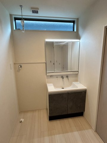 【秀光ビルド】大垣市昼飯町Ⅰ期1号地分譲住宅の洗面所|洗面化粧台：洗髪機能付きハンドシャワー水栓・3面鏡付き洗面化粧台です。上部にビックサイズの開口を配置し光を採り入れています。（2026年7月）撮影 