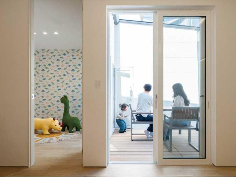 「デザイナーズ平屋」高知市鴨部　新築一戸建ての居間・リビング|室内からキッズルームやウッドデッキへ視線が届く安心設計。家族の時間をもっと豊かに。