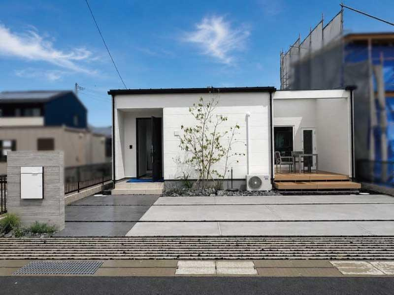 「デザイナーズ平屋」高知市鴨部　新築一戸建ての外観|開放的なウッドデッキと、広々とした駐車スペースを完備したスタイリッシュな佇まい。