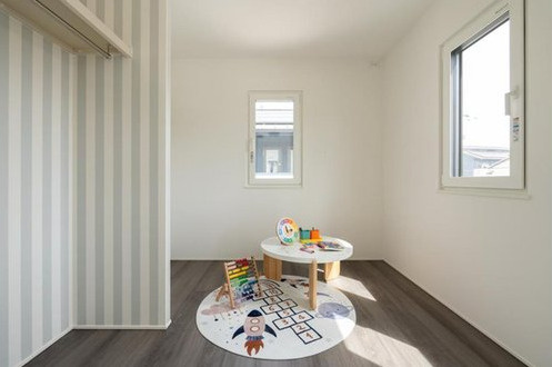 「大きな吹き抜けがある住まい」高知市鴨部　新築一戸建ての洋室|ストライプのアクセントクロスが可愛らしい、明るい洋室スペース。