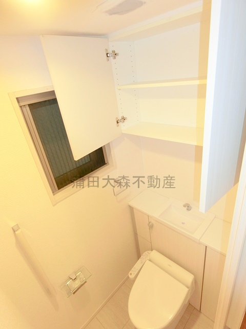 ライオンズ大森西グランフォートのトイレ|吊戸棚と窓、温水洗浄便座付きのトイレ