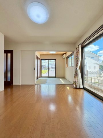 守山市小島町　中古戸建ての居間・リビング|大きな窓から明るさを取り込むLDK。和室まで視線が抜け、空間を広く感じられます。