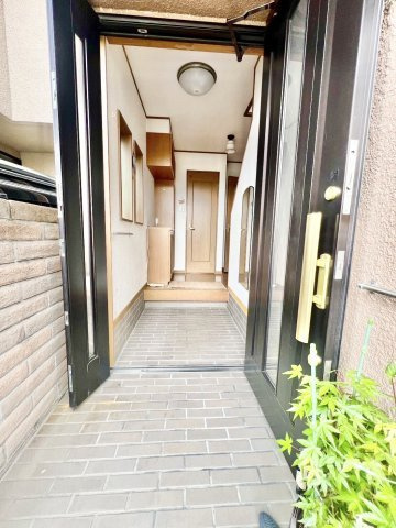 中古戸建　伊丹市池尻3丁目のエントランス|タイル敷きの落ち着いたアプローチが広がる玄関。開放感があり、家族やゲストを心地よく迎え入れます。