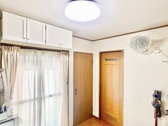 中古戸建　伊丹市池尻3丁目の居間・リビング|DKから洗面所、奥の浴室へと一直線につながる間取り。水回りが集約され、家事や入浴の動線がスムーズです。