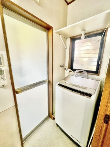 中古戸建　伊丹市池尻3丁目のランドリースペース|窓付きで換気しやすい清潔な洗面スペース。浴室への動線もスムーズで、毎日の脱衣や洗濯が快適に行えます。