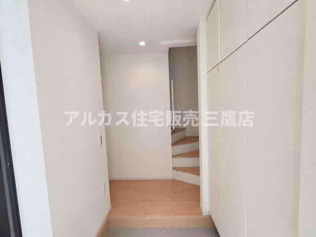 三鷹市井口5丁目 中央線 武蔵境駅 新築戸建の玄関|壁面いっぱいの収納を備えた、白を基調としたすっきりとした玄関ホール。