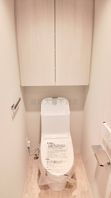 シーズンフラッツ大森西のトイレ|吊戸棚収納と温水洗浄便座付きのトイレ　