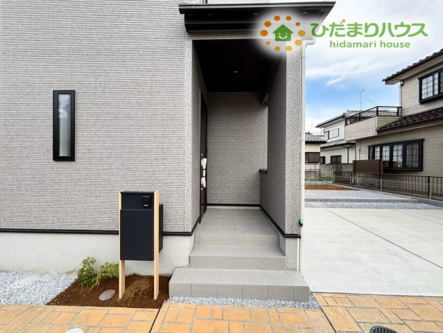 鴻巣市松原4丁目　新築一戸建て　ブルーミングガーデン　01の玄関|落ち着いた印象を与える玄関アプローチです！雨の日でも傘の開閉がしやすい庇（ひさし）が設置されているため、濡れずに室内へ入れます♪段差も緩やかで、小さなお子様やお年寄りも歩きやすい仕様です！