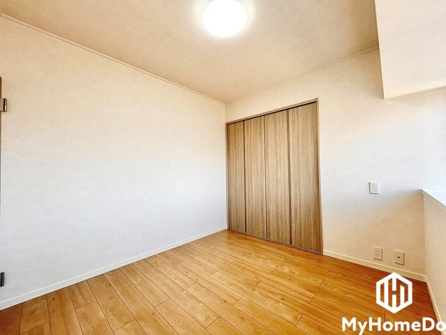 エスポア春日井西館の子供部屋|クローゼット扉とフローリングの木目が統一された綺麗な室内。右側にはカウンター状の空間もあり、ディスプレイ等に活用できます。