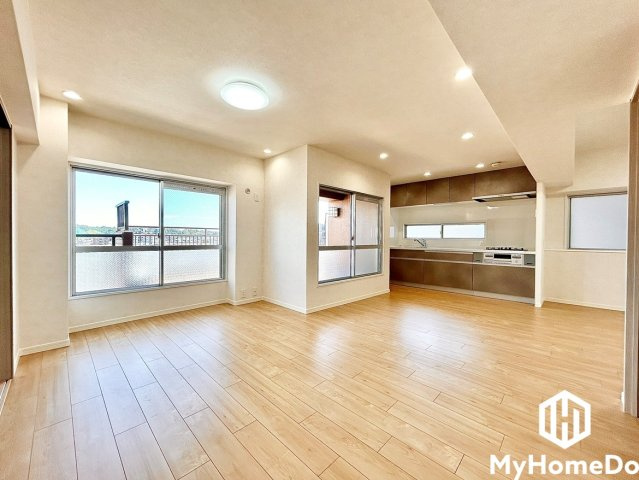 エスポア春日井西館の居間・リビング|大きな窓から青空が広がる心地よい景観。ダウンライトとシーリングライトを配した上品な照明デザインが、上質な空間を演出します。