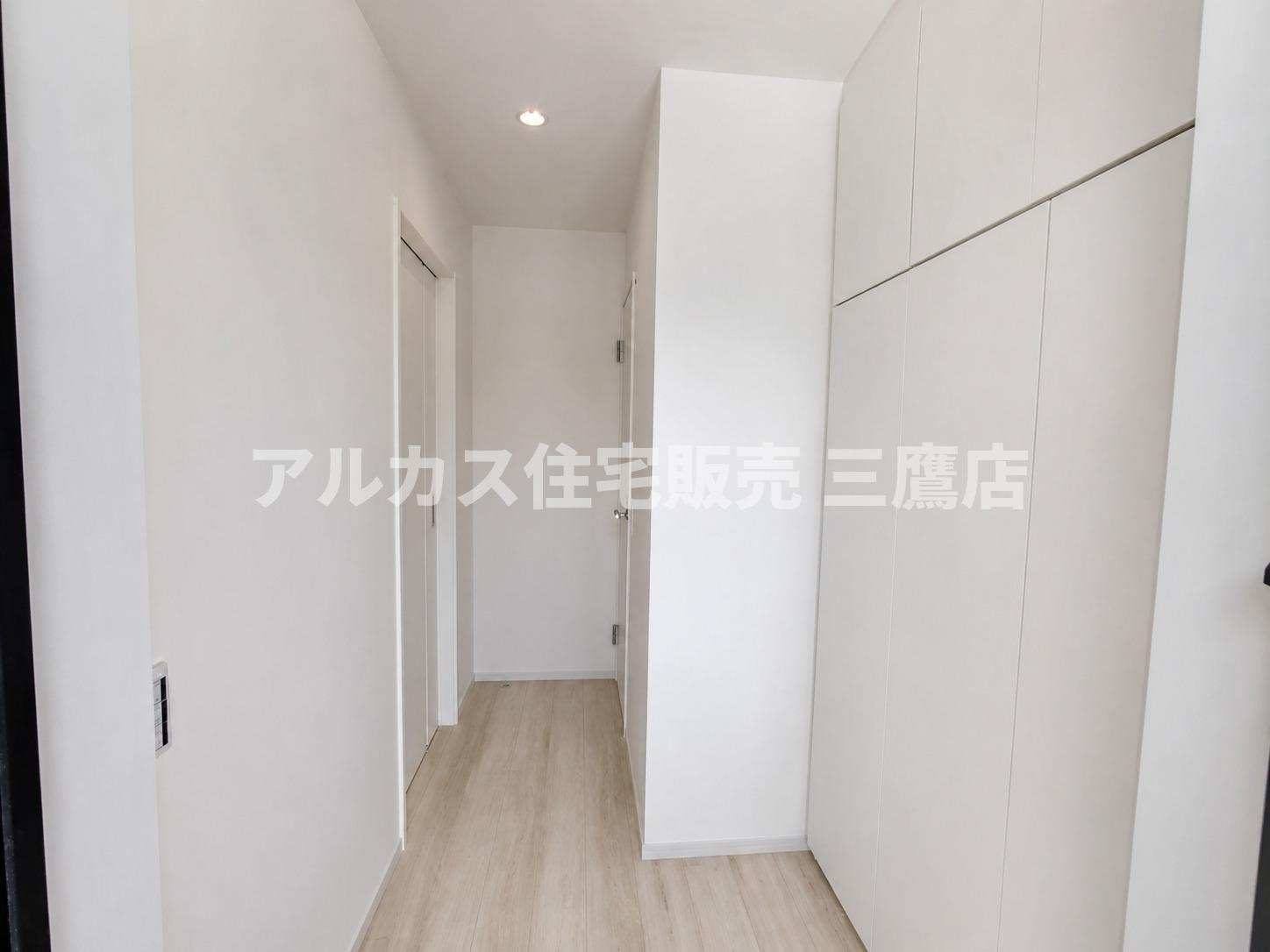 三鷹市井口5丁目 中央線 武蔵境駅 新築戸建の玄関|壁面いっぱいに収納を備えた、白で統一されたすっきりとした玄関廊下。