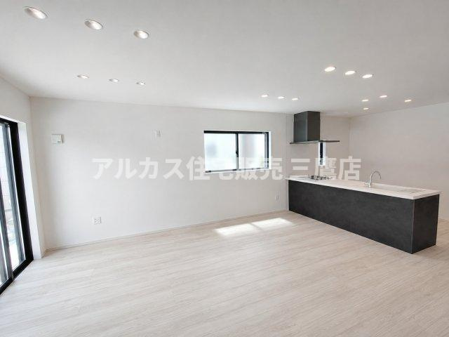 三鷹市井口5丁目 中央線 武蔵境駅 新築戸建の居間・リビング|明るいフローリングとシックなキッチンが調和する、広々としたLDK。