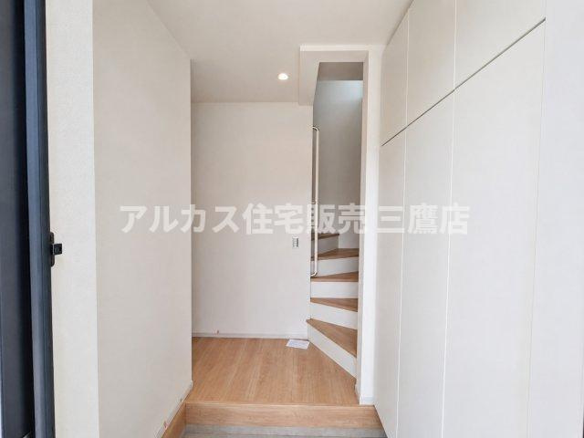 三鷹市井口5丁目 中央線 武蔵境駅 新築戸建の玄関|白を基調とした爽やかな印象で、階上への階段を備えた明るい玄関ホール。