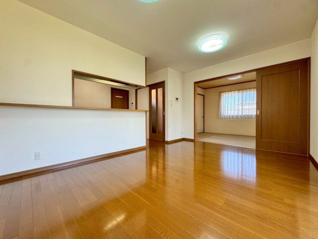 野洲市冨波甲　中古戸建ての居間・リビング|隣接する和室のドアを開けば、お部屋を更に広々と使うことができます。