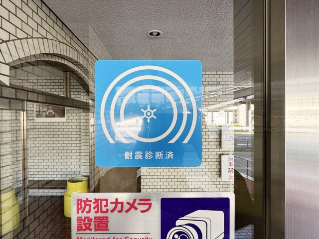 【現況写真】 | 大森ハイツ | エントランスに掲げられた耐震基準適合マーク。安心の新耐震基準であることの証明です。～即日のご見学可能～　お問合せはお気軽にどうぞ。
