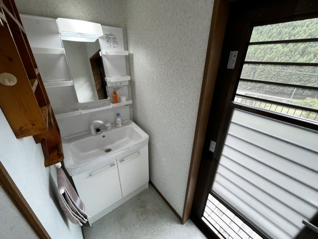 曽爾村伊賀見の洗面所|洗面台の先には緑豊かな山の景色。身支度の時間も気持ちよく過ごせる、明るく開放的な洗面スペースです。