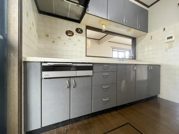 高江中央2丁目中古のキッチン|落ち着いたトーンの扉が特徴的なキッチンです。作業スペースがしっかりと確保されており使いやすいレイアウトとなっています。上部にも収納が備わっており整理整頓がしやすい仕様です。