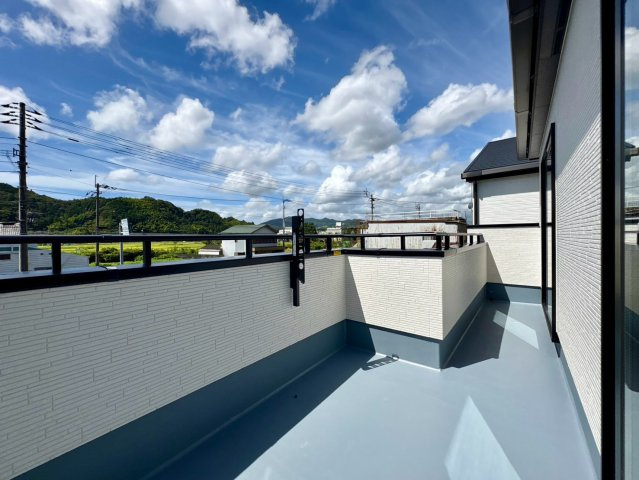 「お洒落な折下天井」吾川郡いの町駅東町2号棟　新築一戸建てのバルコニー|青空が広がる開放感のあるバルコニー！洗濯物もたっぷり干せて気持ちの良い毎日を過ごせます。