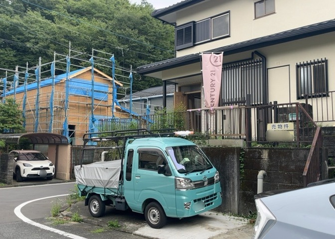 【前面道路含む現地写真】 | 北側は幅員約6.0mの公道に接しており、お車のすれ違いや駐車もスムーズに行えます。角地の開放感ある立地で、日当たりや通風も良好です。高尾台東公園まで275mと近く子育て世帯にも適した環境です。