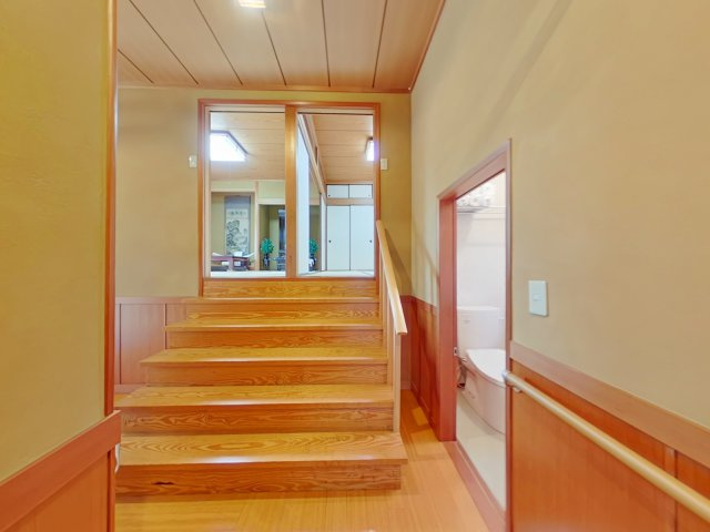 岡山市南区芳泉四丁目　一戸建の内装|やさしい色合いの廊下に、木の階段が印象的な空間です。奥には和室が広がり、落ち着いた暮らしを感じられます。
