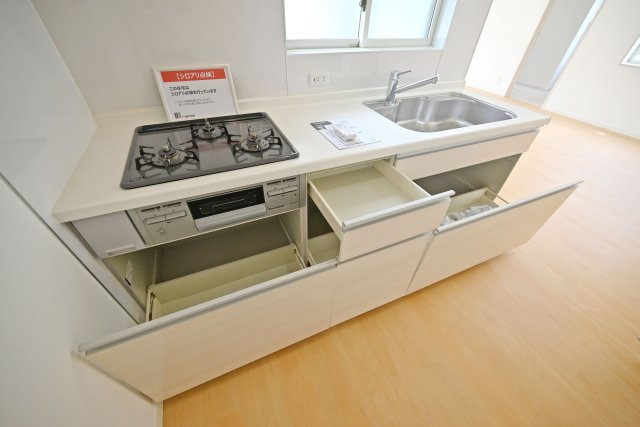 箕面市牧落5丁目中古戸建｜駐車一台可（制限有）のキッチン|広いワークトップはお料理の盛り付けに便利。シンク下の収納スペースには大きなお鍋やフライパンなどの調理器具もスッポリ収納できます。
