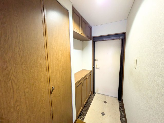 ジョイフルプラザ湊町の玄関|収納が豊富なゆとりある玄関。落ち着いた木目調の扉と、上品な質感の床面が優しく迎えてくれます。