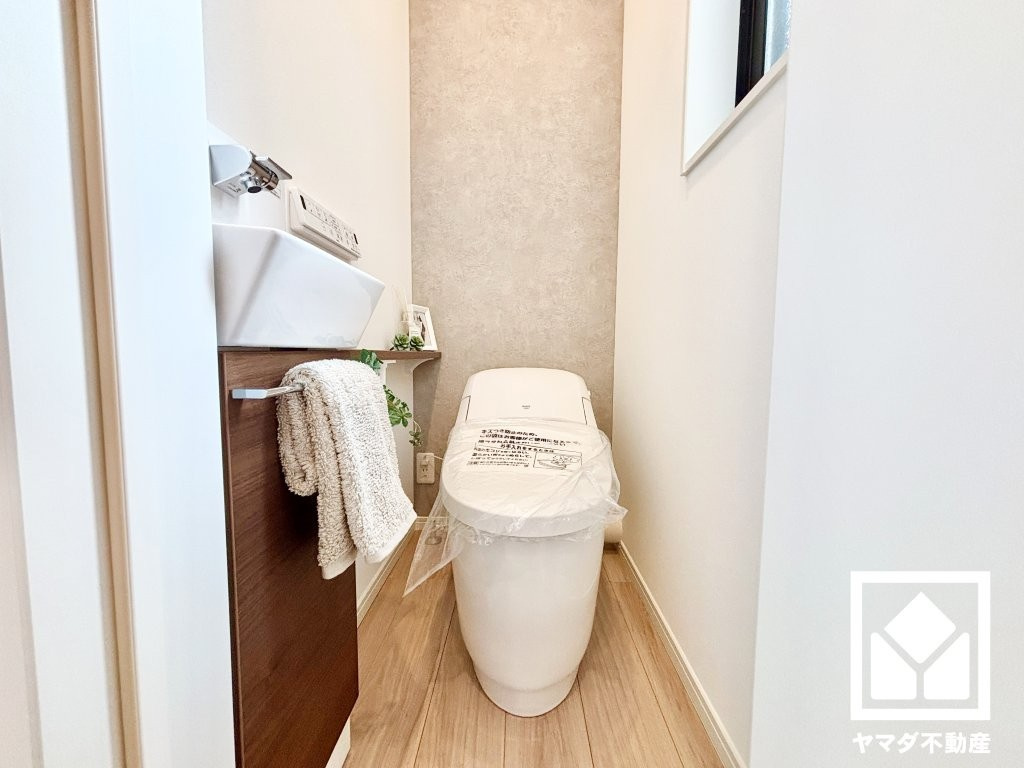西宮市瓦林町のトイレ|スッキリとしたデザインでお手入れがしやすいタンクレス風トイレを採用。手洗いが別になっており、使い勝手や衛生面にも配慮された仕様です。