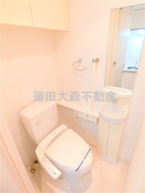 ドゥーエ蒲田のトイレ|吊戸棚と手洗いと温水洗浄便座付きのトイレ
