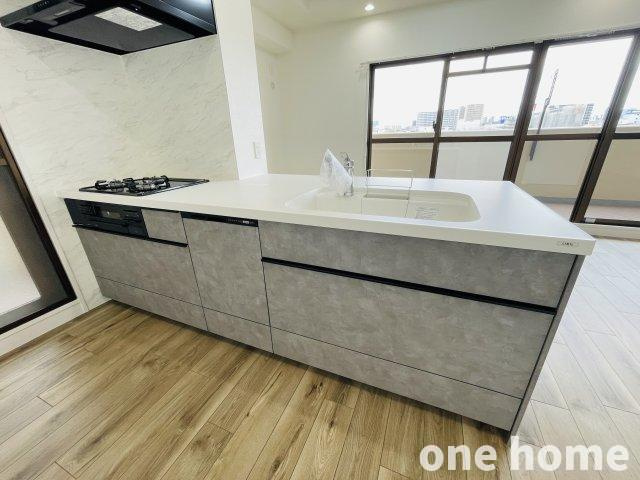 キングマンション千船弐番館のキッチン|◆新調されたシステムキッチンはグリル付３口ガスコンロ搭載！カウンター付きでお料理の配膳などもスムーズです！
◆便利な2WAY動線で、キッチンから直接、洗面室へ通じます！勝手口もあり家事動線良好です！