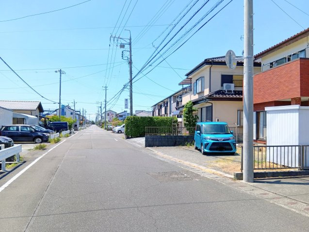 売土地　焼津市石津港町の前面道路含む現地写真|西側方向：ゆったりとした道路幅で駐車もスムーズ。周辺に住宅が建ち並ぶ、落ち着いた住環境が魅力です。