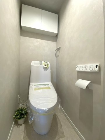 セルカディア鎌ヶ谷大仏のトイレ|新規交換済みの快適な温水洗浄便座付きトイレです。清潔感のあるスタイリッシュなデザインで、日常のお手入れもしやすい仕様です。ペーパー類や掃除用品をスマートに収納できる棚も完備されています。