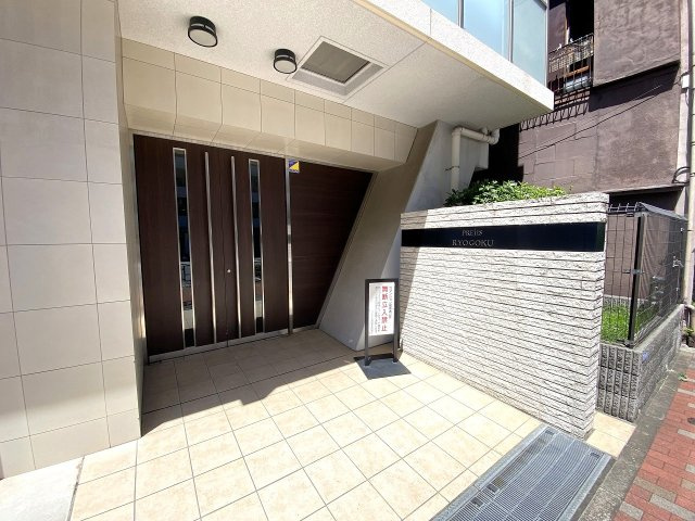 プレシス両国|マンションの顔となる重厚感あるエントランス入口です。美しく整備されたアプローチは住まう人や訪れるゲストを優しく迎え入れます。管理体制の良さが伺える、きれいに維持・管理された共有スペースです。