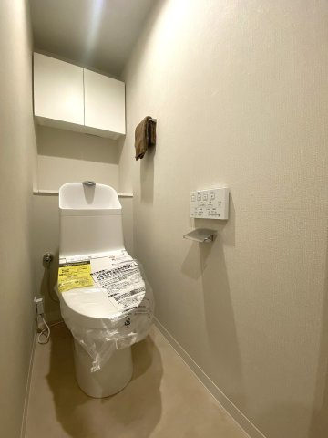若葉台マンションのトイレ|清潔感のある新規交換済みの温水洗浄便座付きトイレです。節水機能やお手入れのしやすさに優れており、毎日快適にご使用いただけます。上部吊戸棚などの収納スペースも充実しており空間をすっきり保てます。