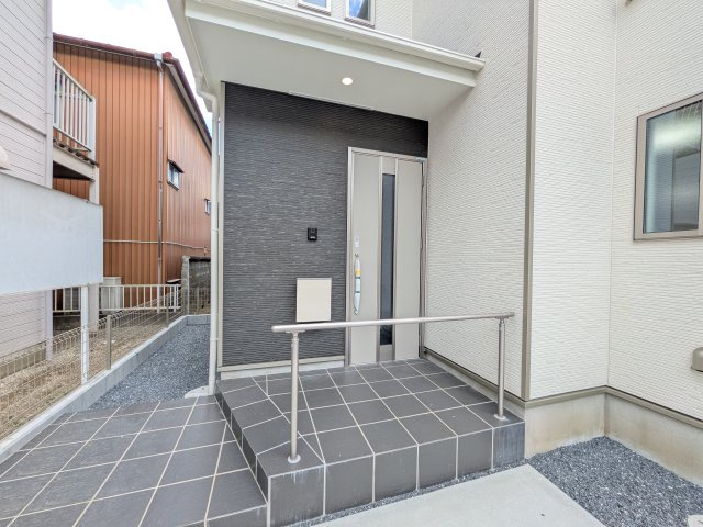 水戸市曙町1番37　新築戸建て　A号棟の玄関|お洒落な玄関ドアと洗練された外壁デザイン。家の顔にふさわしい上質な佇まいで、ご家族やお客様を迎えます。