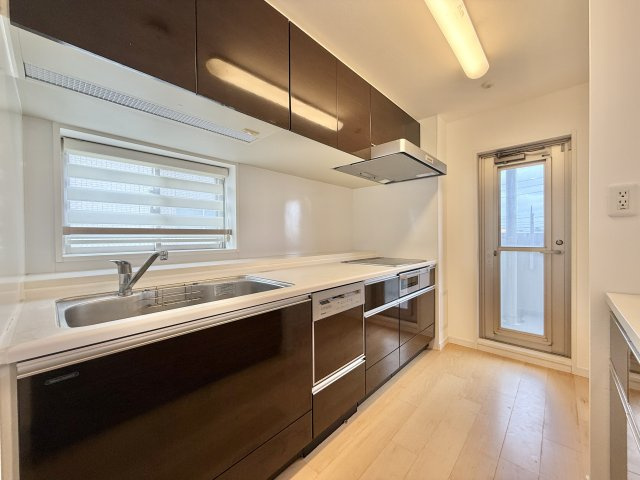 プレミスト佐藤　のキッチン|マンションで、キッチンに窓があるのもタイプは珍しいです。料理をしながら外を眺めることもできますし、窓を開けて空気の入れ替えをすることもできますよ。キッチン横にはバルコニーに出られるドアも付いています。