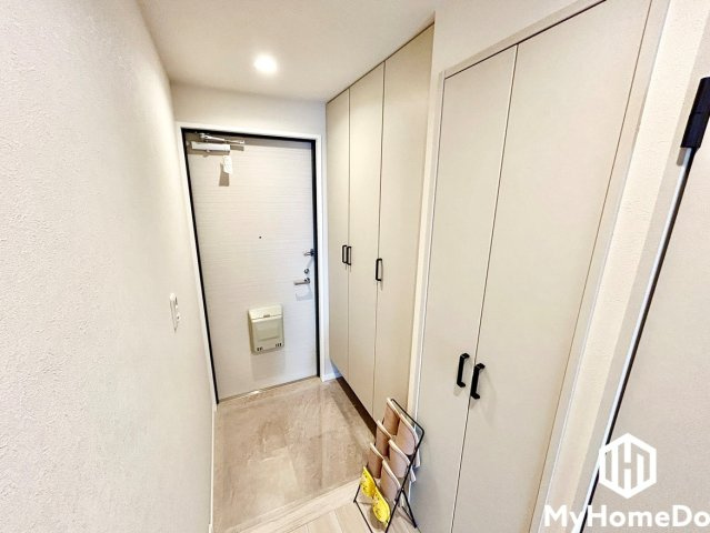 アンビックス志賀ストリートタワーの玄関|壁面に沿って天井近くまで高さのあるシステム収納が設置されており、家族全員の靴類をすっきりと収められます。